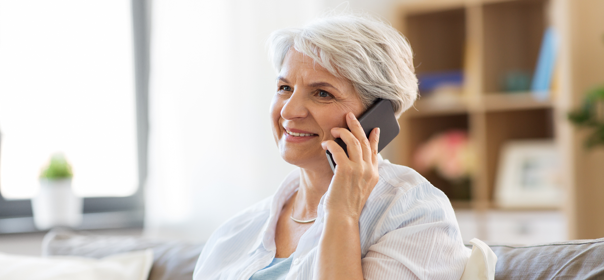 Senior woman talking on the phone with a Lincoln Park dental office